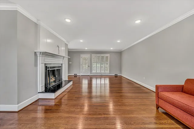 a view of empty room with wooden floor and fireplace