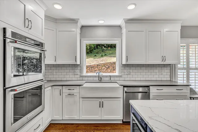 a kitchen with granite countertop white cabinets and white appliances