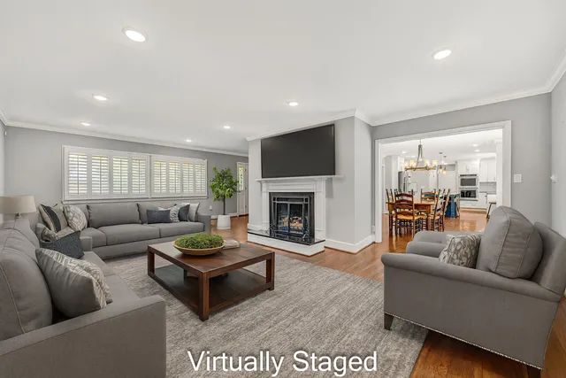 a living room with furniture a fireplace and a large window