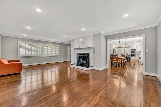 an empty room with wooden floor and fireplace