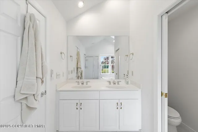 a bathroom with a sink a mirror and next to a window