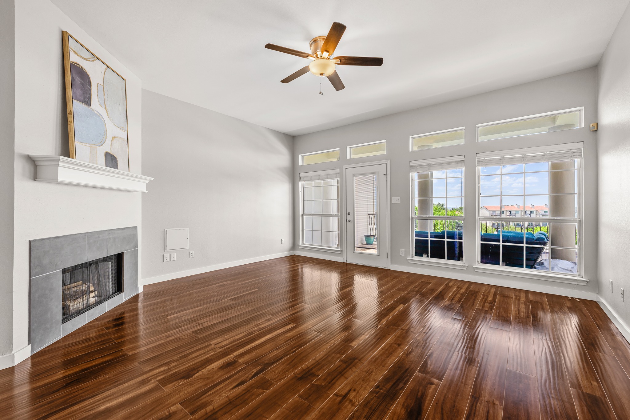 2918 Ranch Road 620 North, Unit S242 Austin, TX 78734 - Photo 12 of 35 Natural light floods a spacious living area, showcasing rich hardwood floors and a modern fireplace.