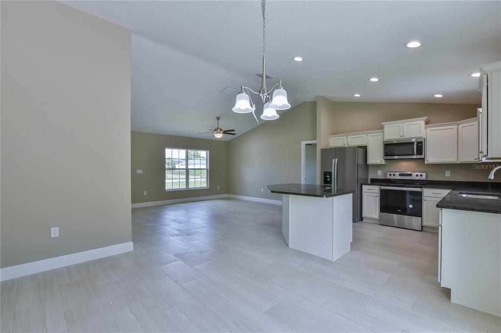 16219 Southwest 48th Circle Ocala, FL 34473 - Photo 23 of 36 a view of a kitchen with a sink and dishwasher a stove top oven with wooden floor