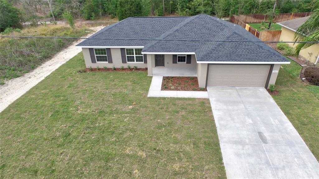 16219 Southwest 48th Circle Ocala, FL 34473 - Photo 4 of 36 a aerial view of a house next to a yard with big trees