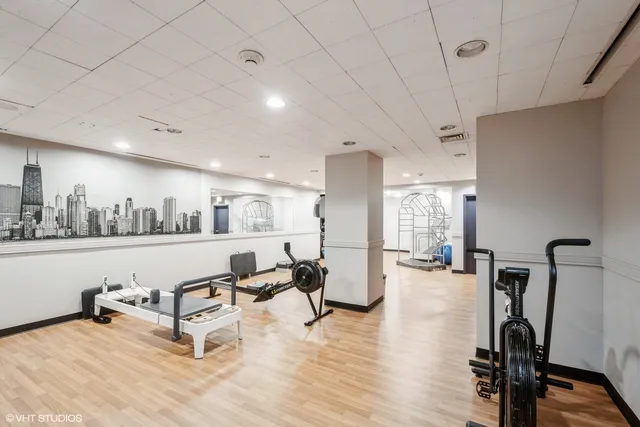 a living room with furniture gym equipment and a large window