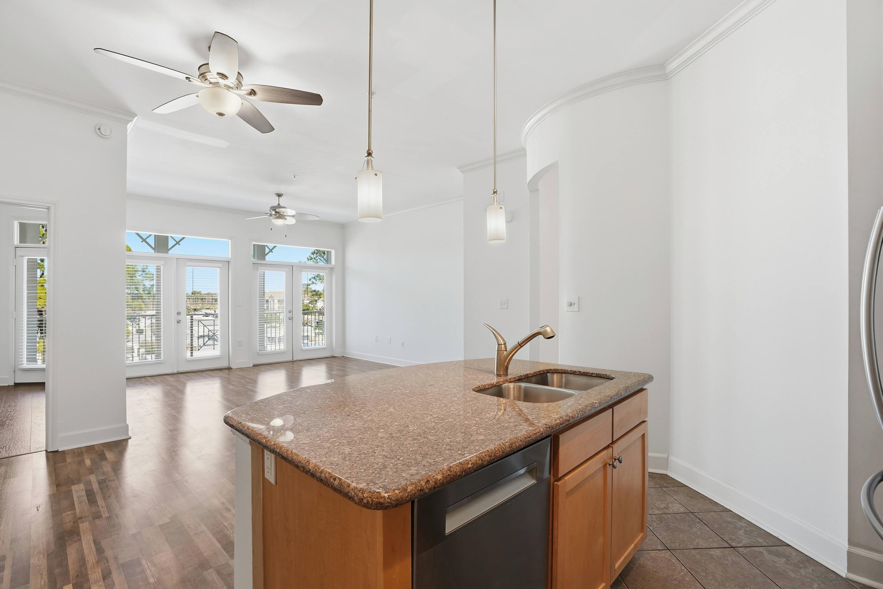 a kitchen with a sink a counter space and wooden floor
