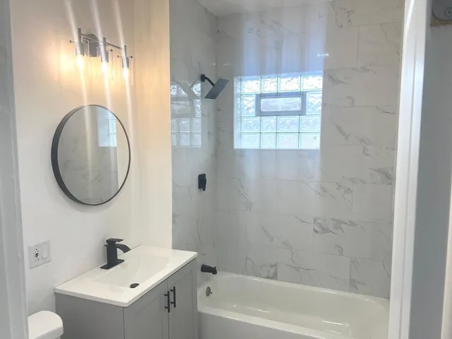 a bathroom with a sink a toilet and shower