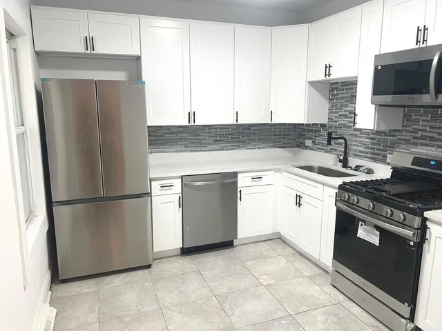 a kitchen with a stove top oven a sink and cabinets