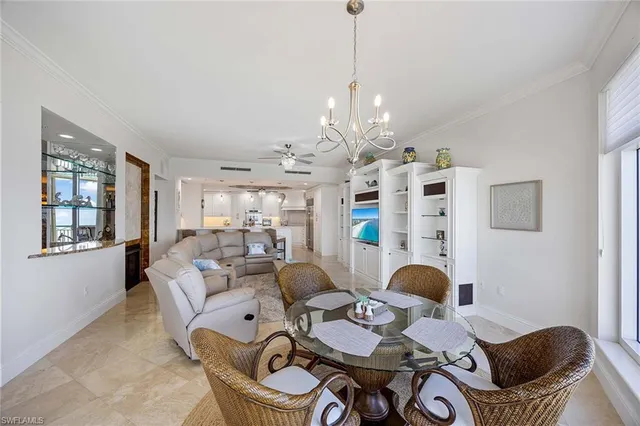 a large white kitchen with cabinets and chairs