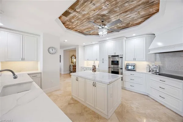 a large white kitchen with a large window
