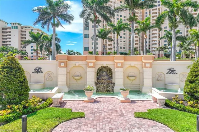 a front view of a house with a yard and fountain