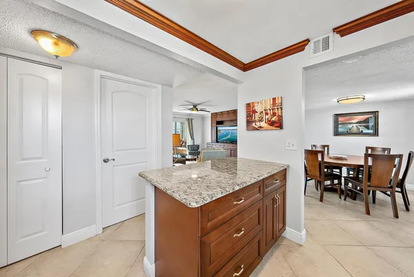 a view of kitchen island with granite countertop cabinets and a table