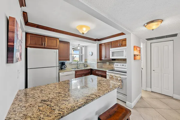 a kitchen with stainless steel appliances granite countertop a refrigerator and a sink