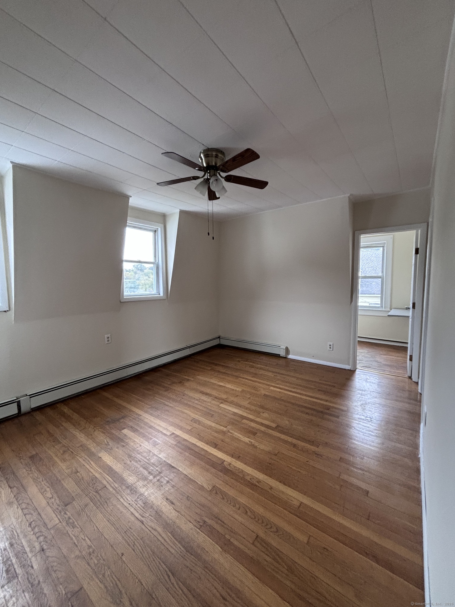 33 Aetna Street, Unit 2 Naugatuck, CT 06770 - Photo 4 of 4 an empty room with wooden floor chandelier fan and windows