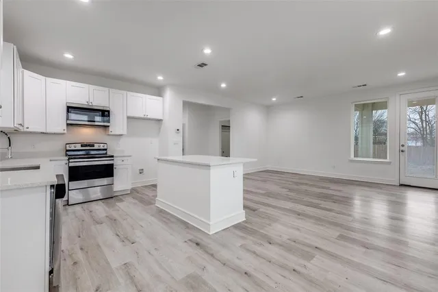 a kitchen with wooden floors and appliances