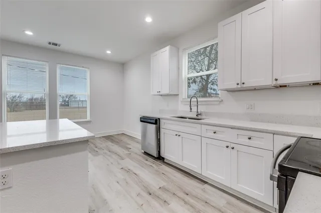a kitchen with granite countertop white cabinets and white appliances
