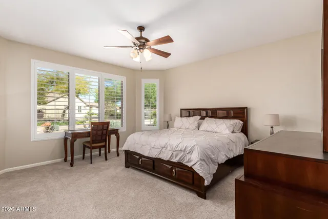 a spacious bedroom with a bed and a table chair