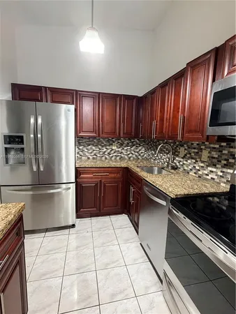a kitchen with stainless steel appliances granite countertop a refrigerator stove and oven