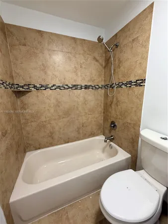 a white bath tub sitting next to a white toilet and a sink