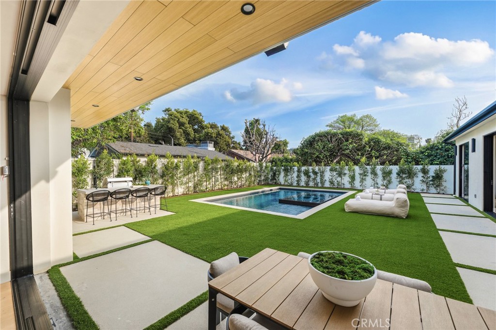 16252 Addison Street Encino, CA 91436 - Photo 27 of 36 a view of a chairs and table in patio with a lake view
