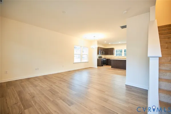 a view of empty room with kitchen and window