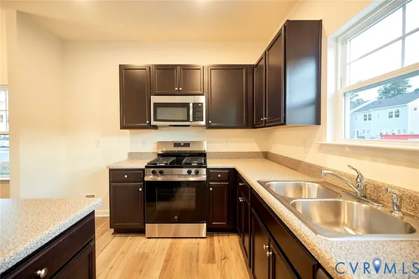 a kitchen with a sink stove top oven and microwave