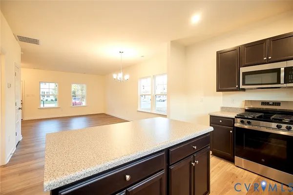 a kitchen with stainless steel appliances a stove a microwave a sink and cabinets