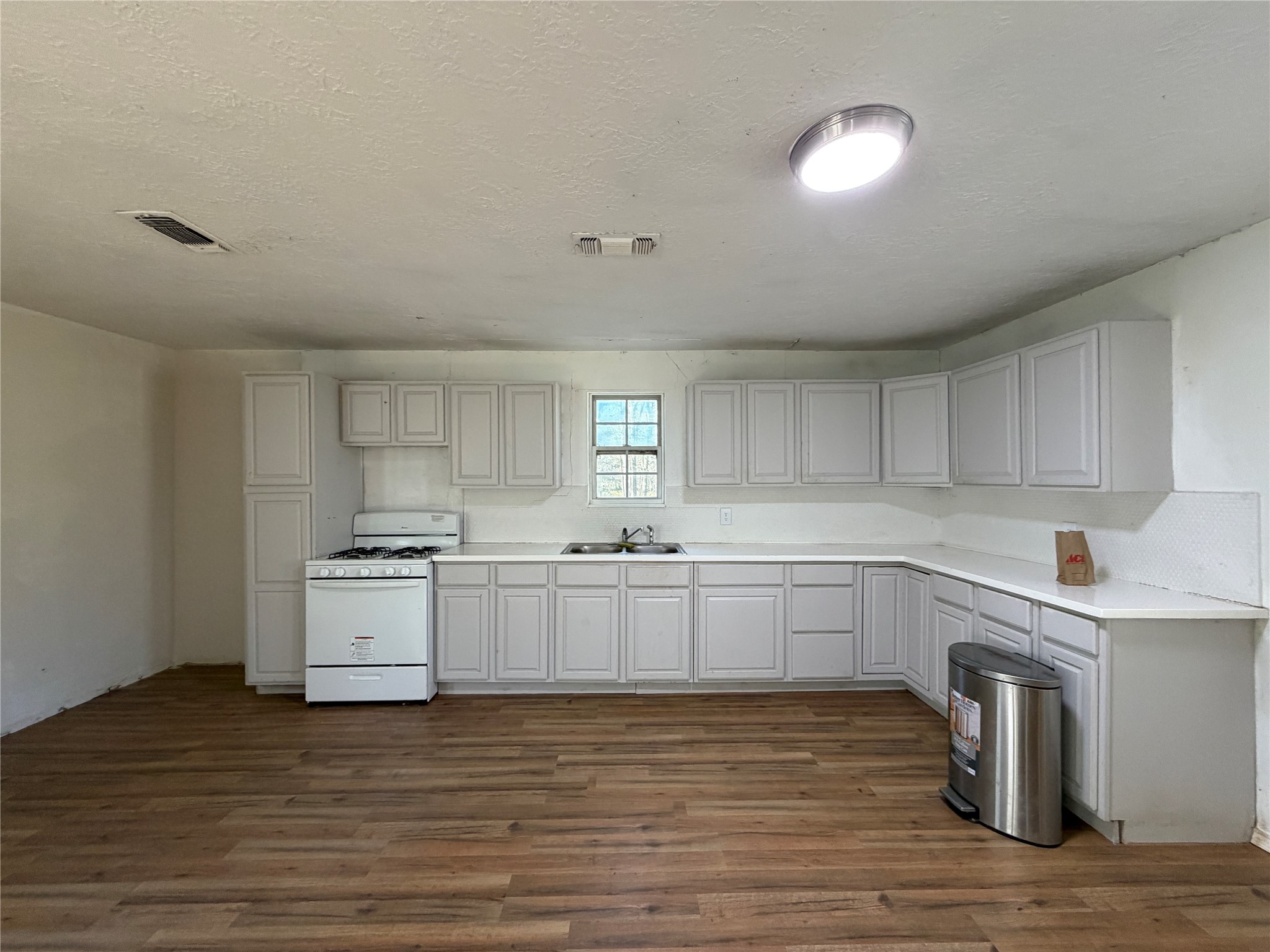 397 County Road 2117 Cleveland, TX 77327 - Photo 6 of 46 a kitchen with sink a stove and cabinets