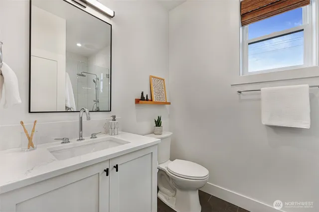a bathroom with a toilet a sink a vanity and mirror