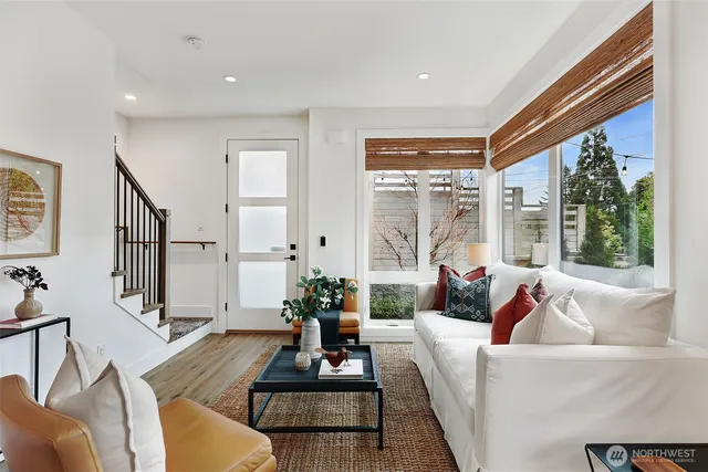 a living room with furniture floor to ceiling window and wooden floor