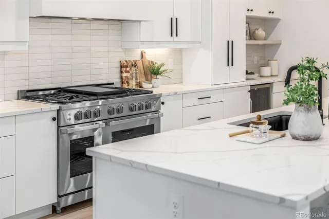 a kitchen with a stove and white cabinets