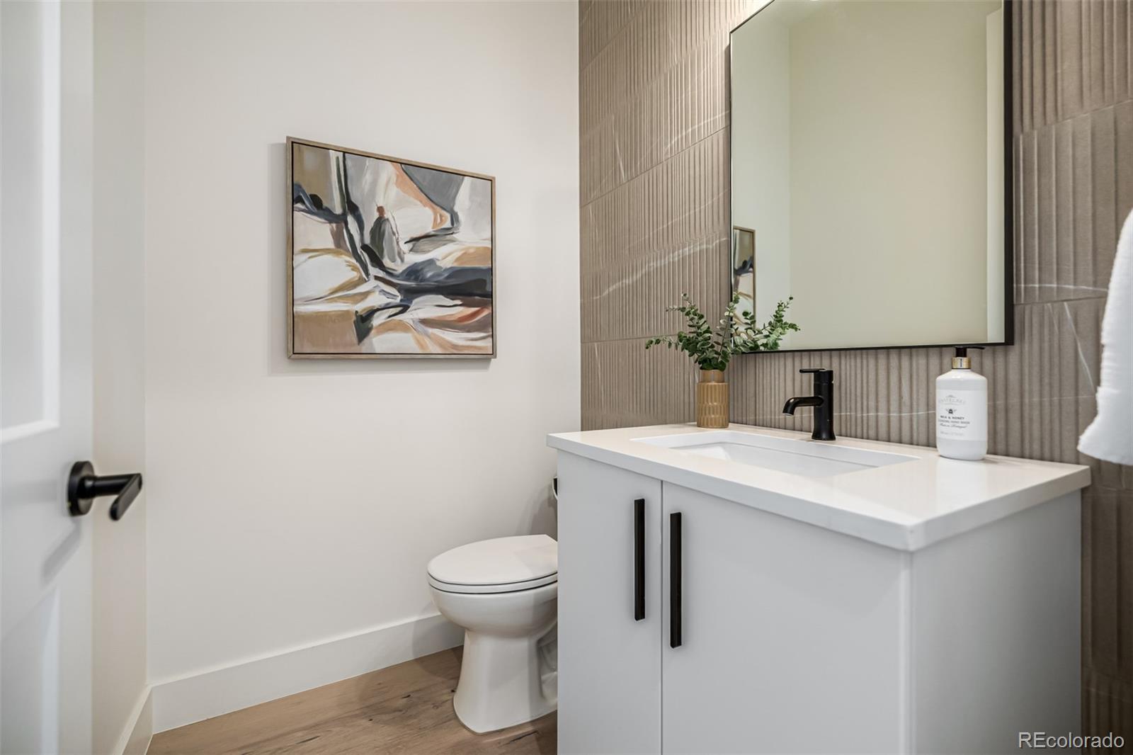 5904 West 37th Place Wheat Ridge, CO 80212 - Photo 19 of 50 a bathroom with a sink a toilet and mirror