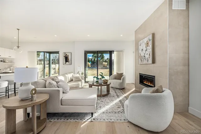 a living room with furniture a fireplace and a floor to ceiling window