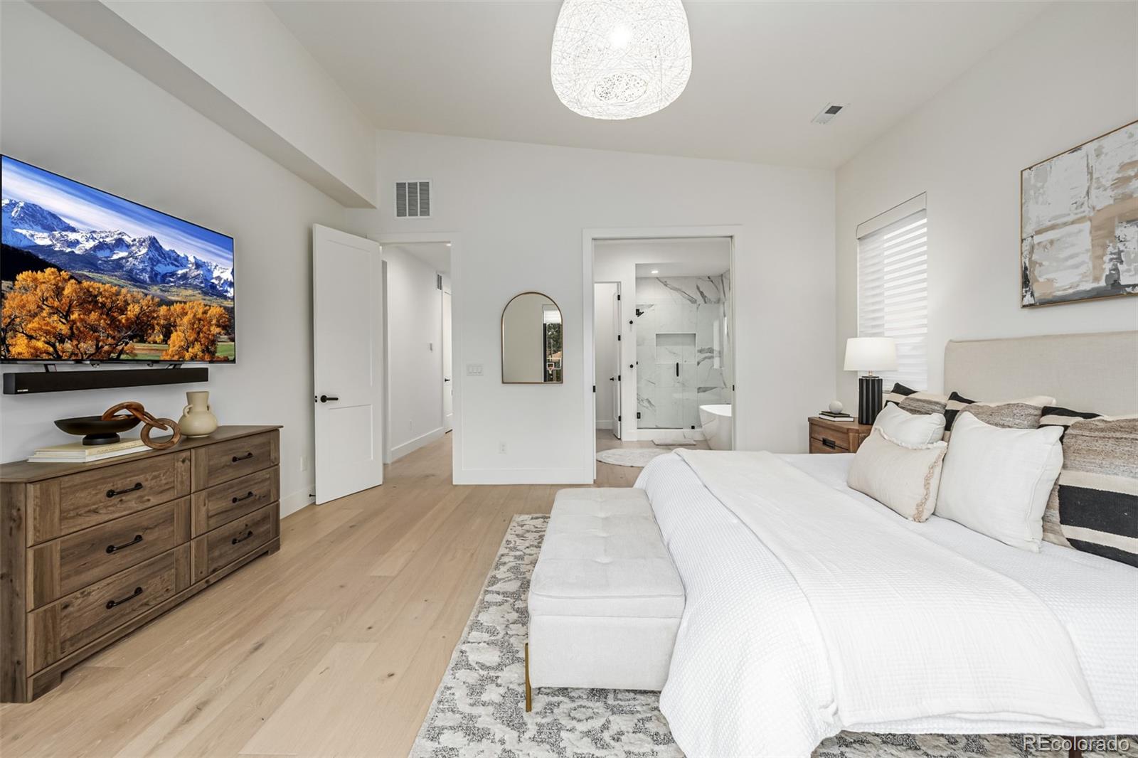5904 West 37th Place Wheat Ridge, CO 80212 - Photo 21 of 50 a bedroom with a bed and a flat screen tv