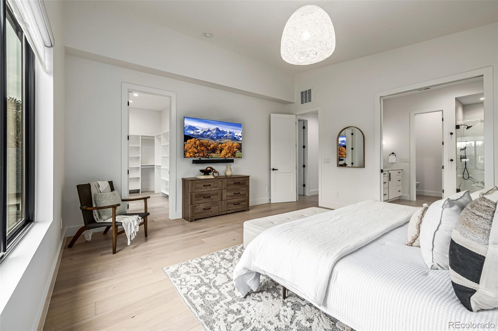 5904 West 37th Place Wheat Ridge, CO 80212 - Photo 22 of 50 a spacious bedroom with a bed and a flat screen tv