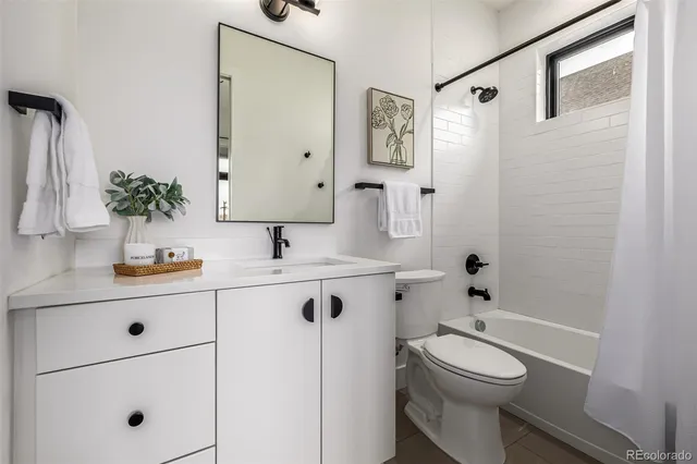 a spacious bedroom with two beds and painting on the wall