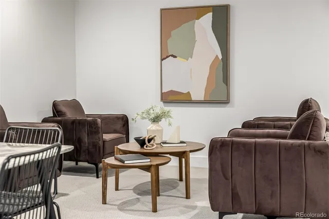 a living room with furniture a couch and painting on the wall