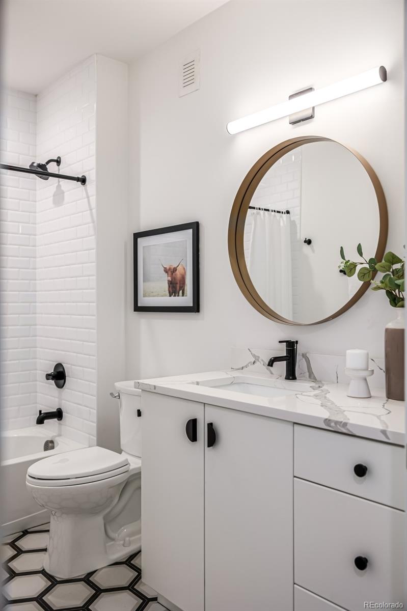 5904 West 37th Place Wheat Ridge, CO 80212 - Photo 40 of 50 a bathroom with a toilet a sink and mirror