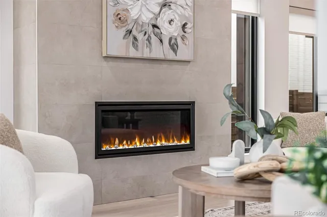 a living room with furniture a fireplace and wall paintings