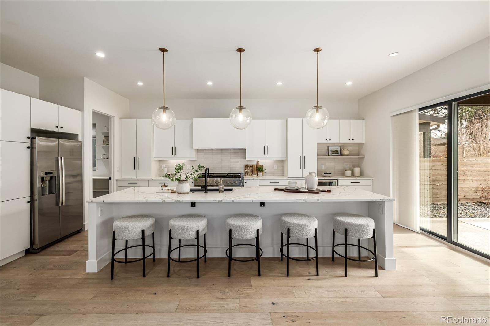 5904 West 37th Place Wheat Ridge, CO 80212 - Photo 7 of 50 a large kitchen with kitchen island a dining table and chairs