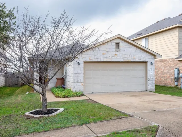 a front view of a house with a yard and tree