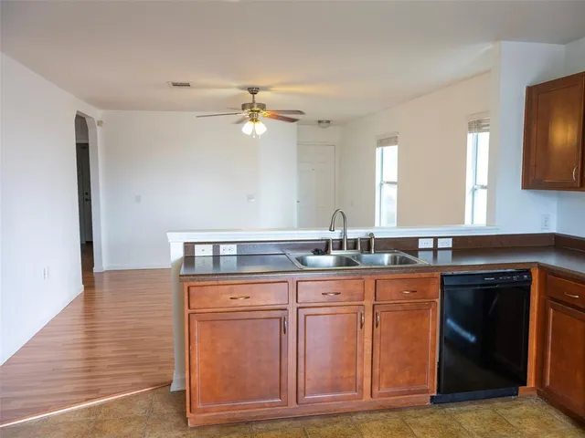 a kitchen with granite countertop a sink cabinets and stainless steel appliances
