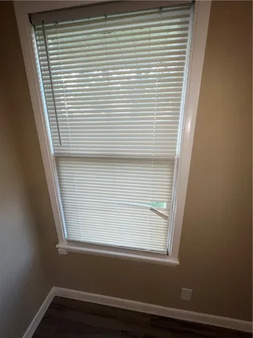 a view of a kitchen with refrigerator and wooden floor