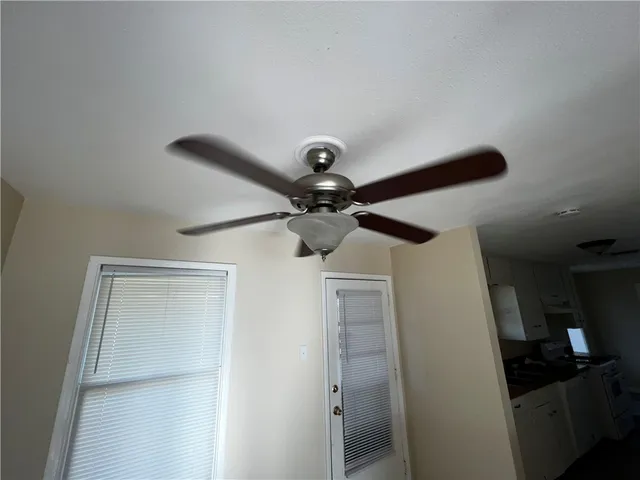a view of a room with wooden floor and a ceiling fan