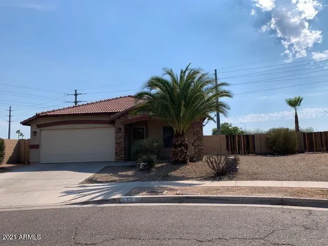 a view of a house with a yard and potted plants