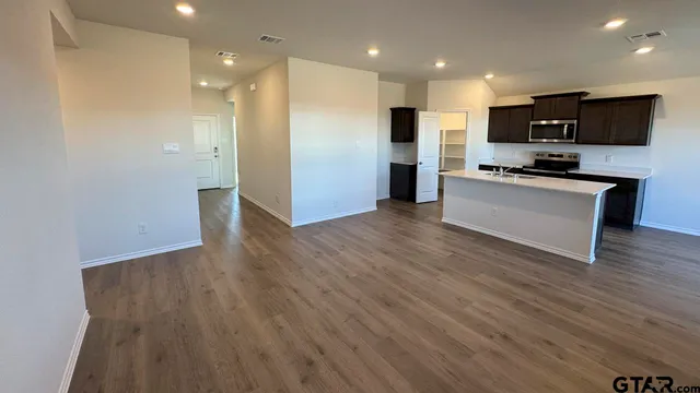 a view of kitchen with stainless steel appliances kitchen island wooden floor and window