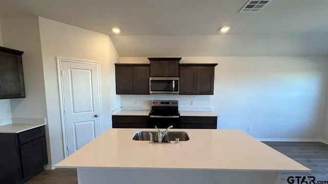 a kitchen with a sink a microwave and cabinets