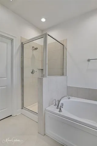 a bathroom with a bathtub a shower a sink and mirror