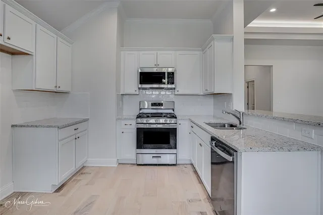a kitchen with granite countertop a stove sink and cabinets