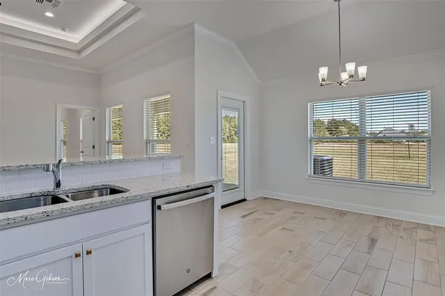 a kitchen with granite countertop a sink and cabinets
